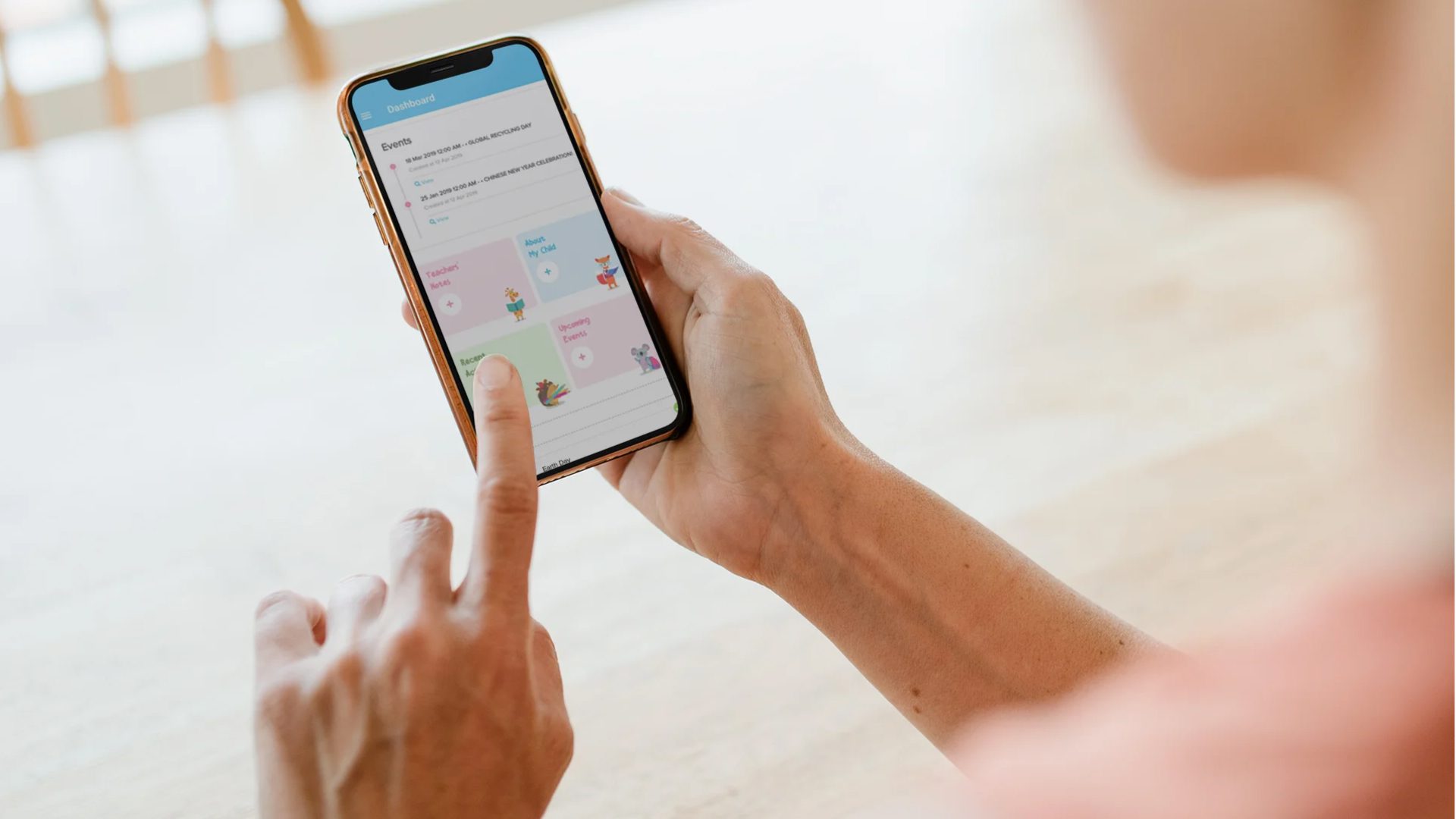 Woman using the KinderConnect mobile app on her phone